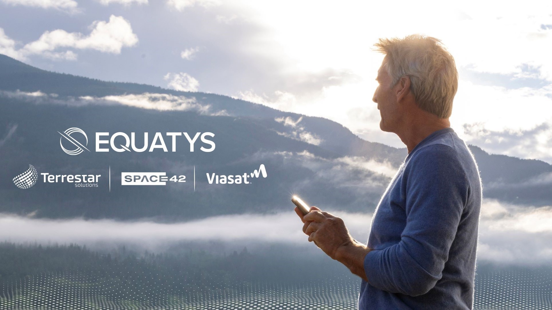 Man holding a smartphone in a misty mountain landscape with Equatys, Space42, and Viasat logos