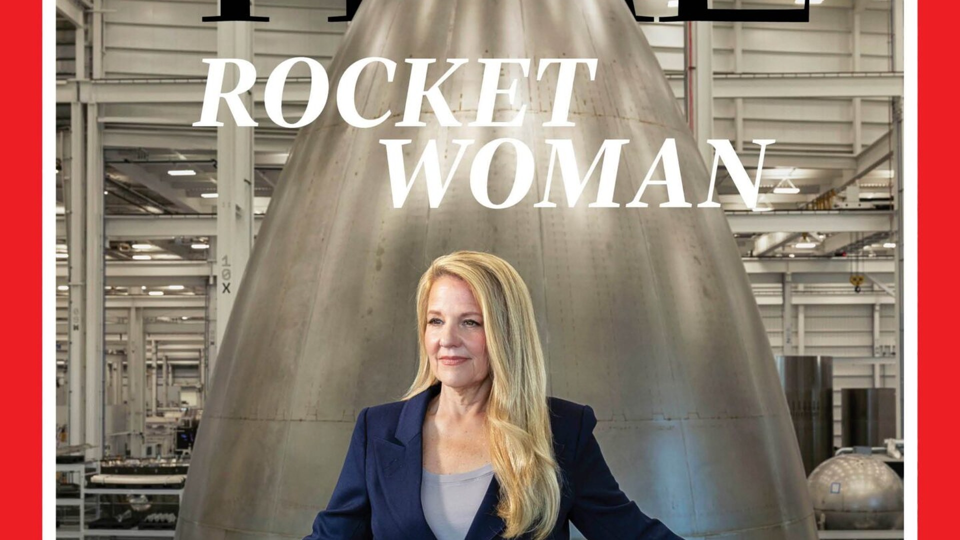 SpaceX President Gwynne Shotwell stands in a rocket factory in front of a metallic nose cone