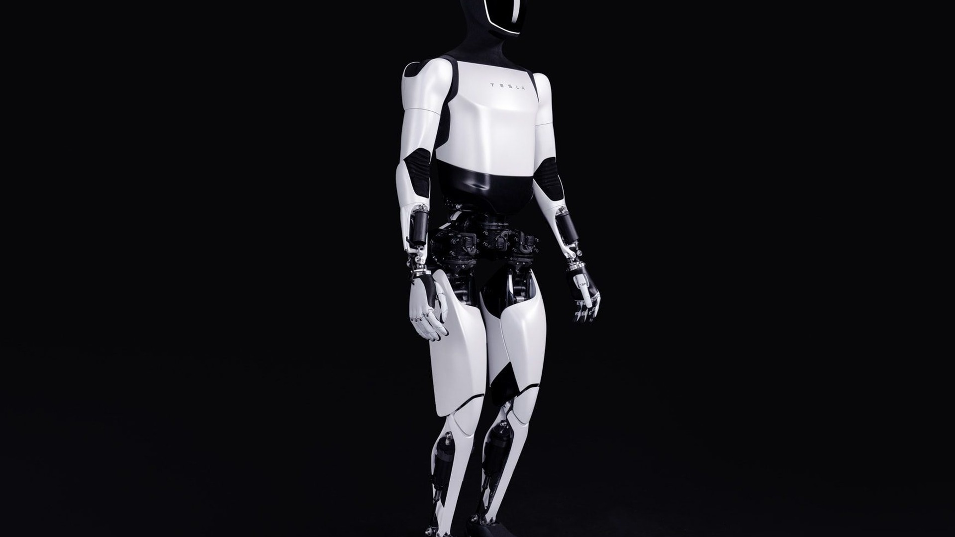 Tesla Optimus Gen 2 humanoid robot standing in a dark studio