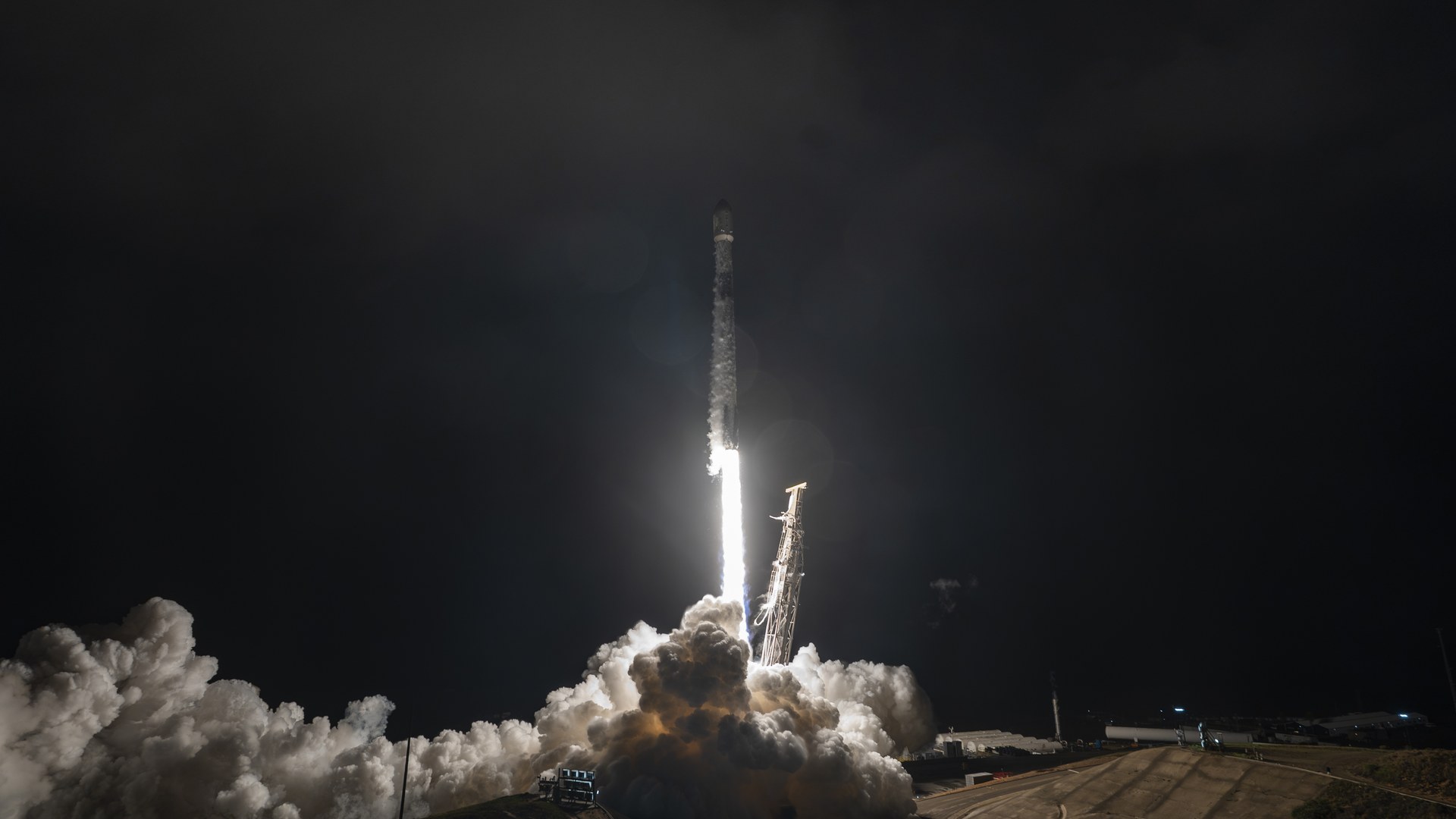 SpaceX Falcon 9 lifting off at night from Vandenberg with a bright engine plume