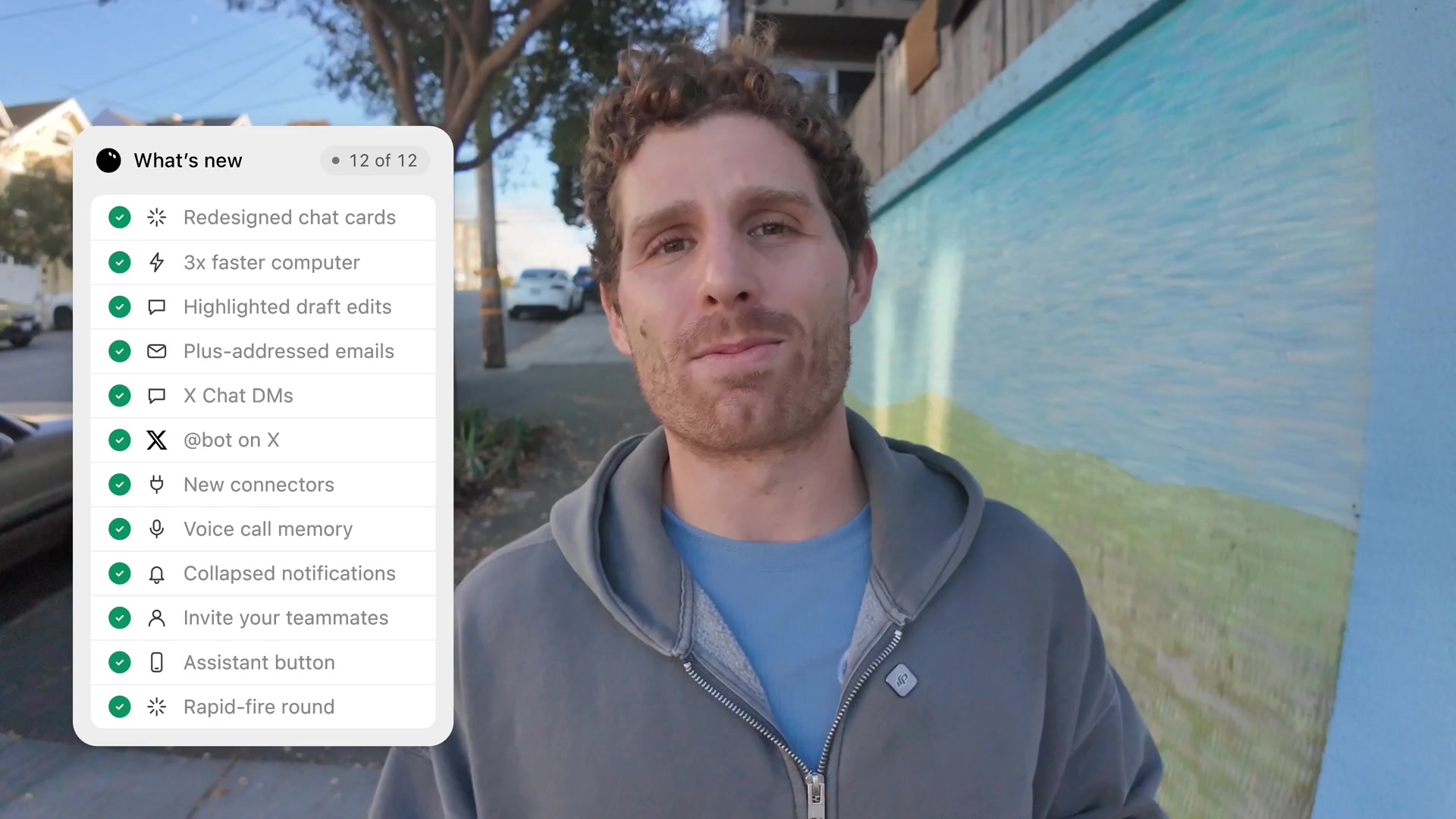 SpaceXSI's Matt Palmer on a San Francisco sidewalk next to an on-screen checklist of new Grok Bot features, including X Chat DMs, @bot on X and the assistant button