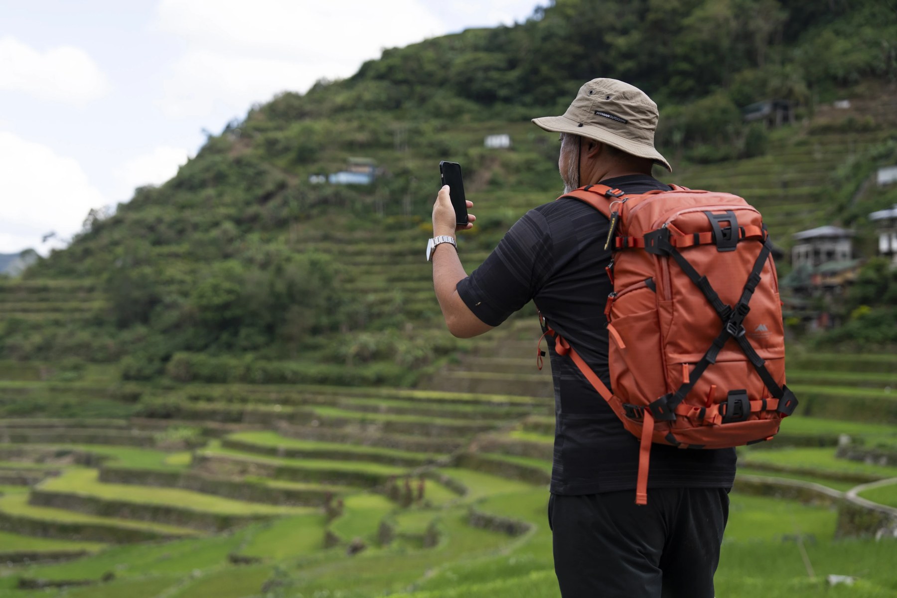 Person holding up a smartphone on green rice terraces, from Starlink's Starlink Mobile page