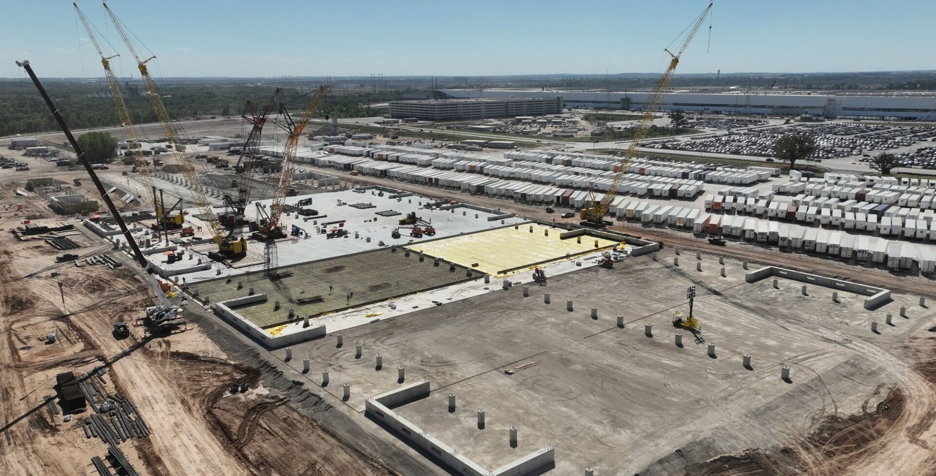 Aerial view of cranes and concrete foundations at Tesla's Austin Fab construction site