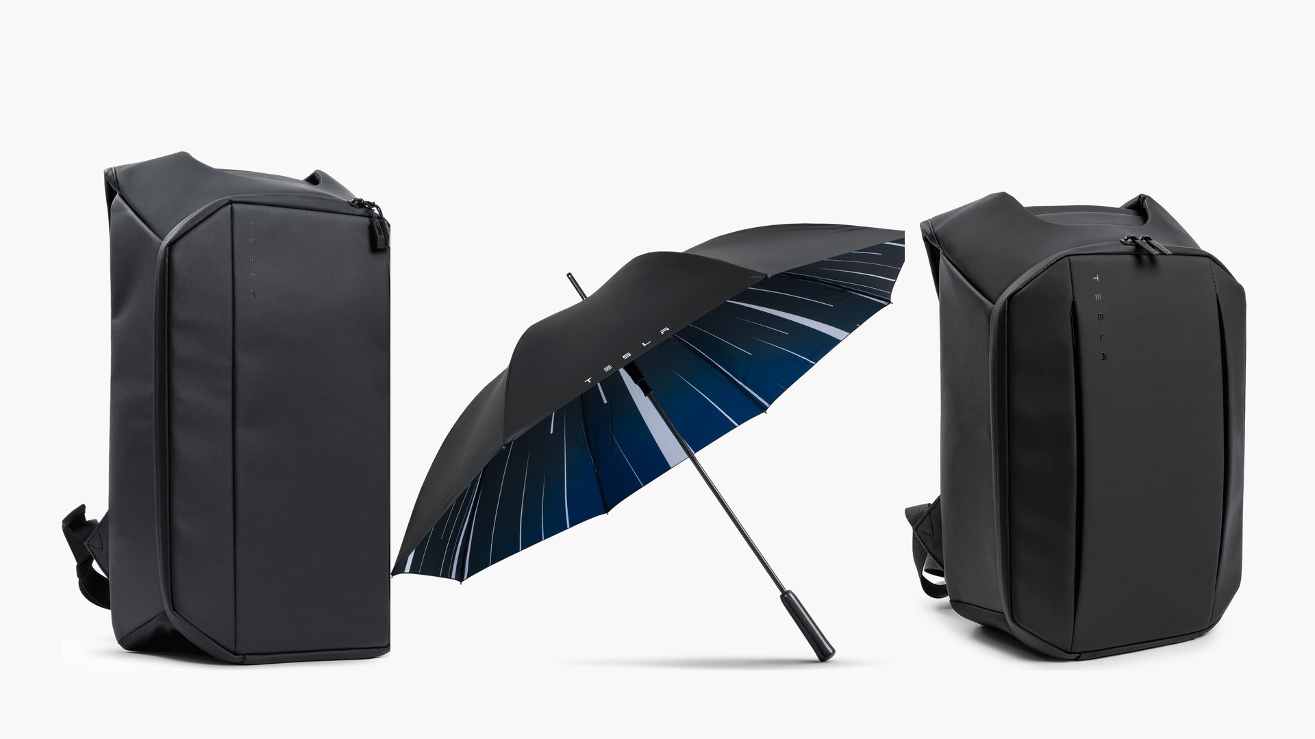 Two tall black backpacks stand on a white background with a dark umbrella opened between them, showing a blue interior and white stripes.