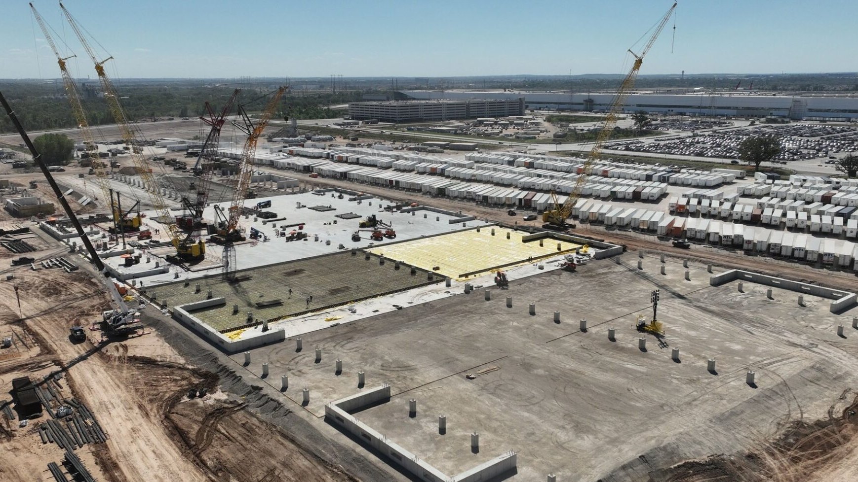 Aerial view of cranes and concrete foundations at Tesla's Austin Fab construction site